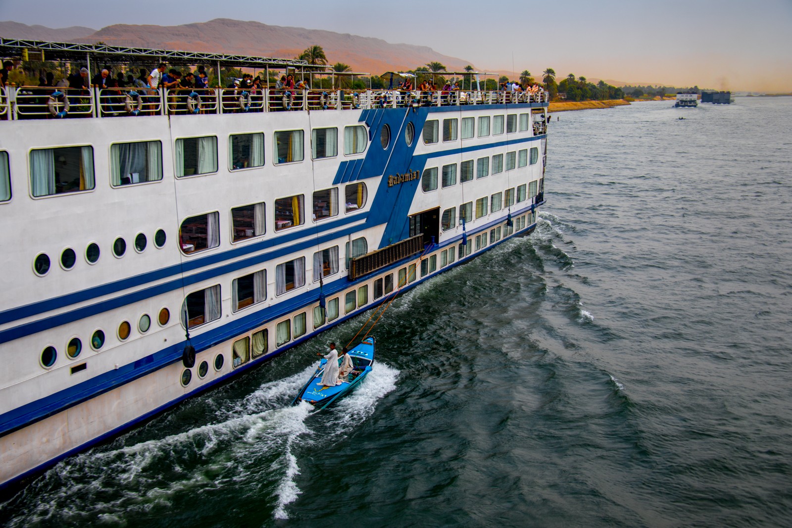 Prodejci tkanin se lanem připoutají k výletní lodi plující po Nilu z Luxoru do Asuánu a nabízejí zboží cestujícím. Tkaniny vyhazují nahoru na palubu - vždy se strefí! Peníze jim zákazníci hází dolů do rozprostřené plachty. - Ladislav Hanousek, Egypt